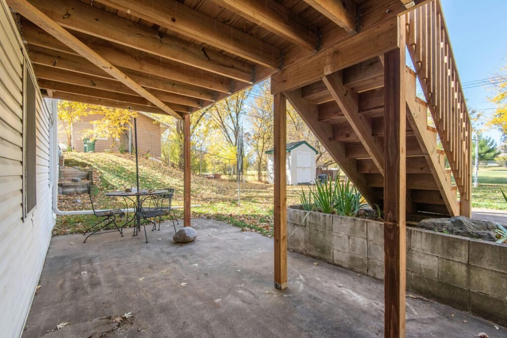 services-2 Outdoor wooden staircase leading to a backyard patio area in a residential setting.